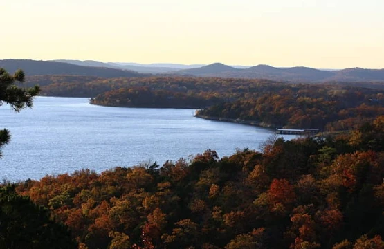 Lake surrounded by hills in autumn color at sunset