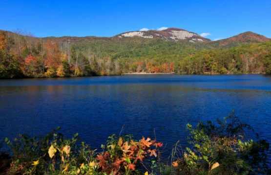 Mountain lake with fall color and a granite peak under blue sky