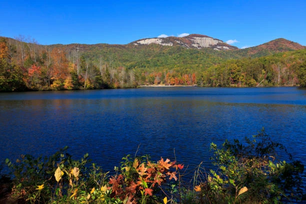 Mountain lake with fall color and a granite peak under blue sky