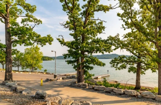 Lakeside park with oak trees, paved path and boat ramp