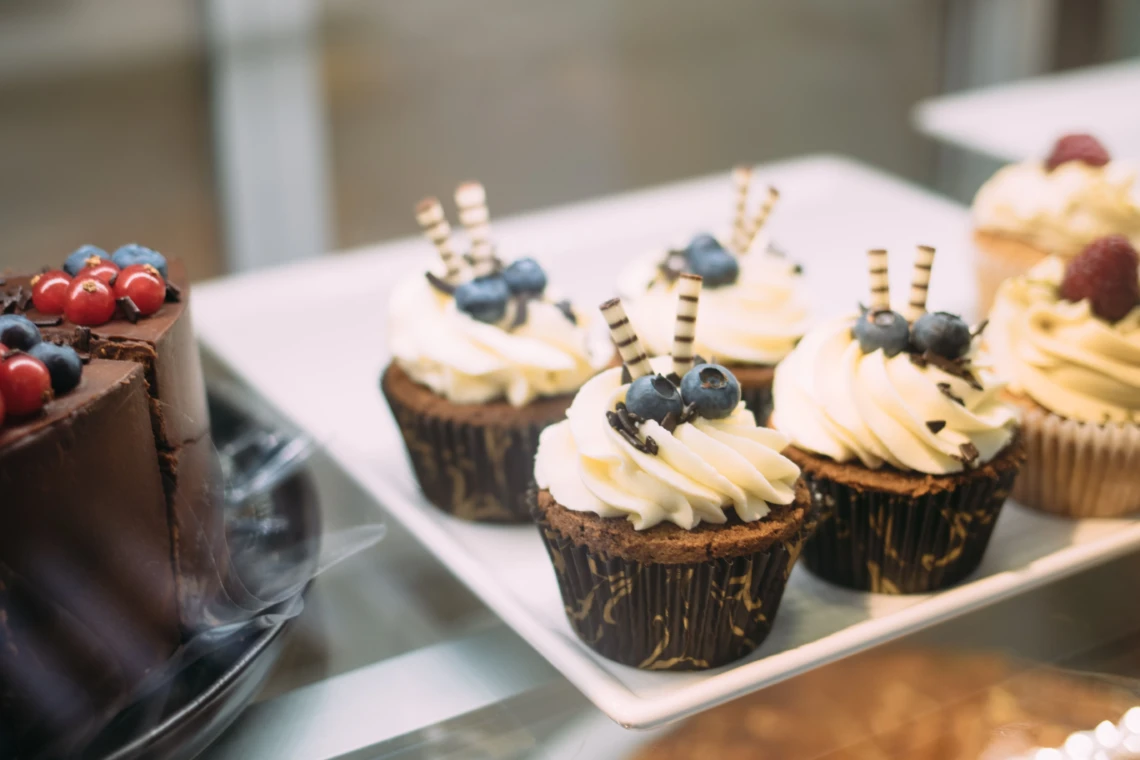 Chocolate cupcakes topped with whipped cream and blueberries