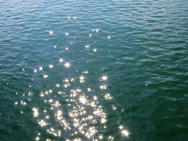 Sunlight sparkling on blue-green lake water