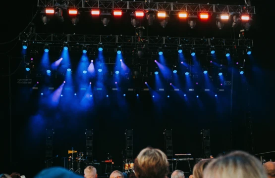 Concert stage with blue spotlights and audience in the foreground
